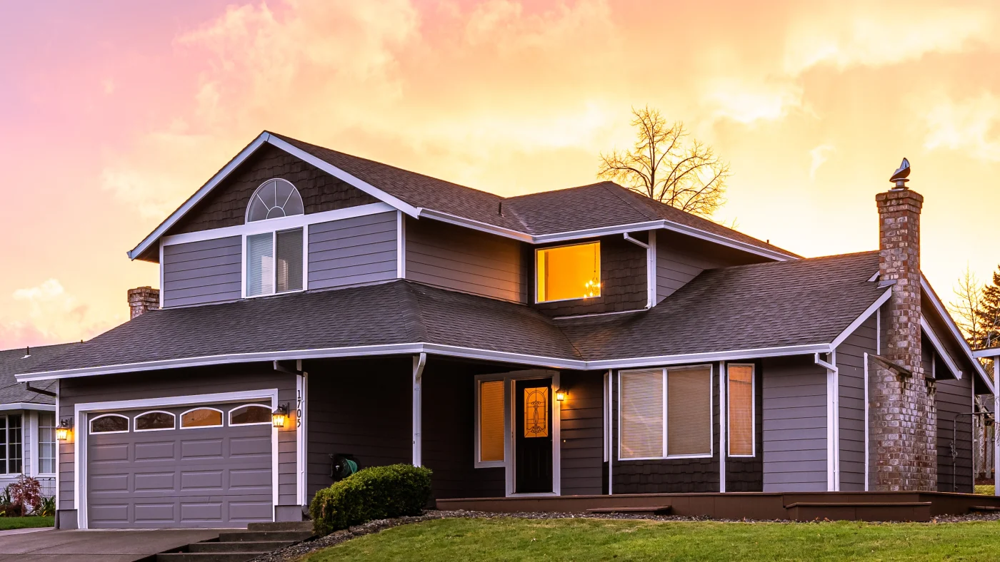A home with gray siding and white trim at sunset