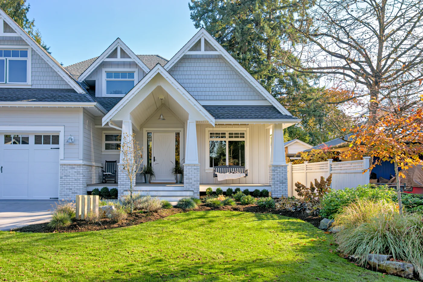 Home with grey shingles roof and white exterior with stone accents
