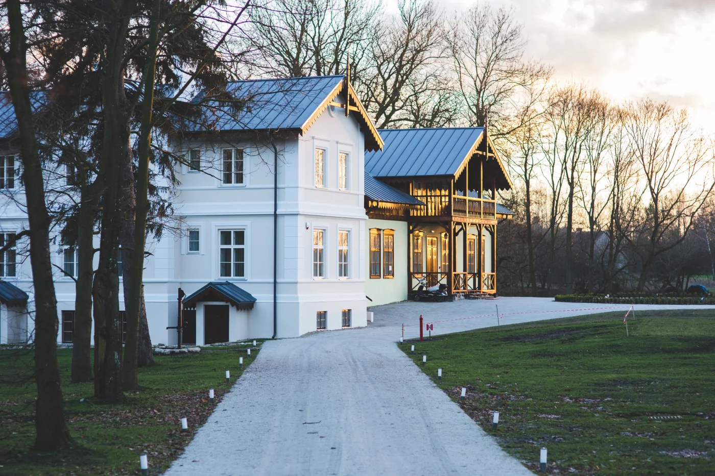 Exterior of three story home with white paint and a standing seam roof