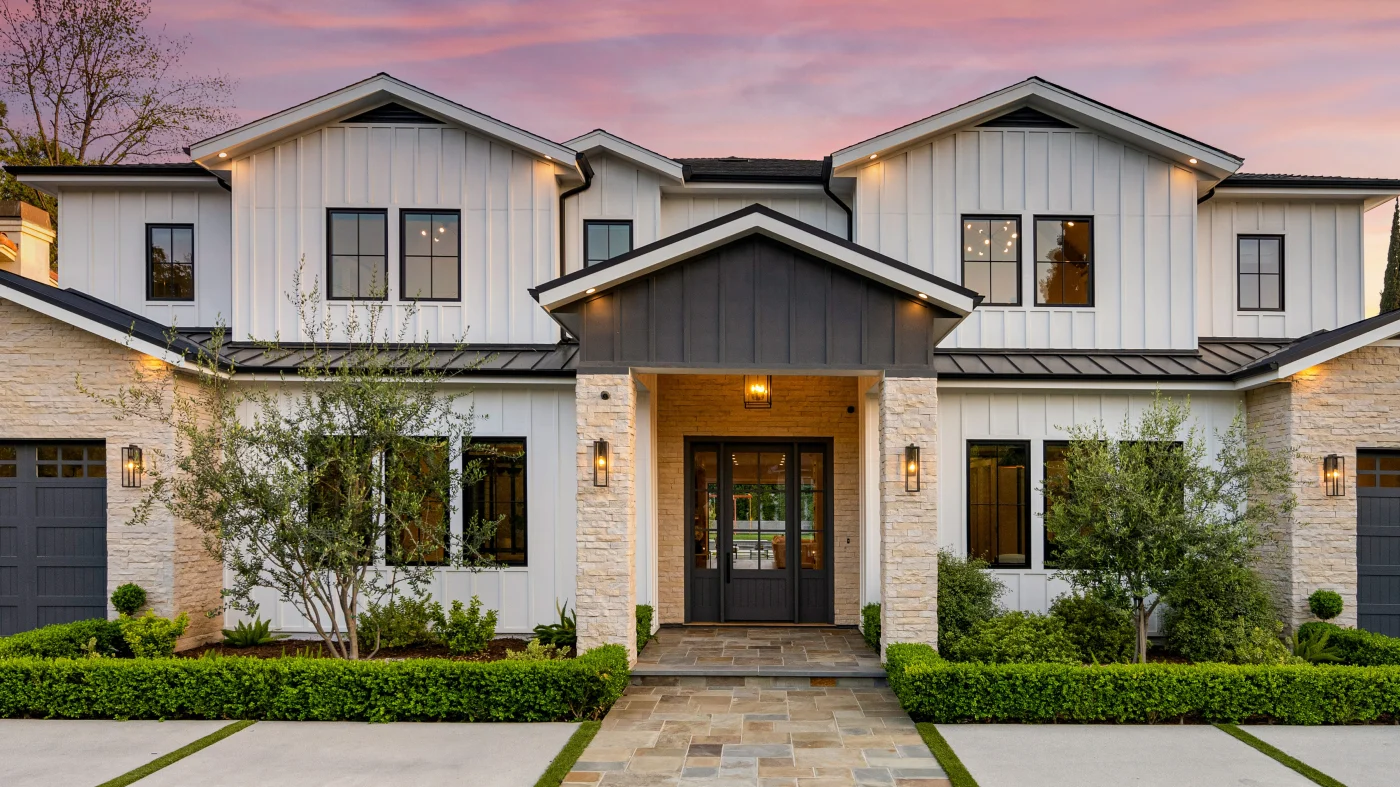 Exterior of a home with white siding and a standing seam metal roof