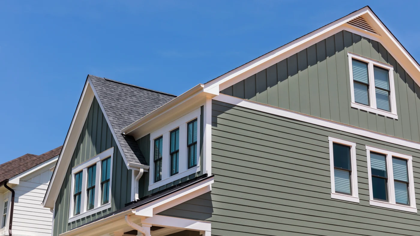 Exterior of a large home with green siding and white trim