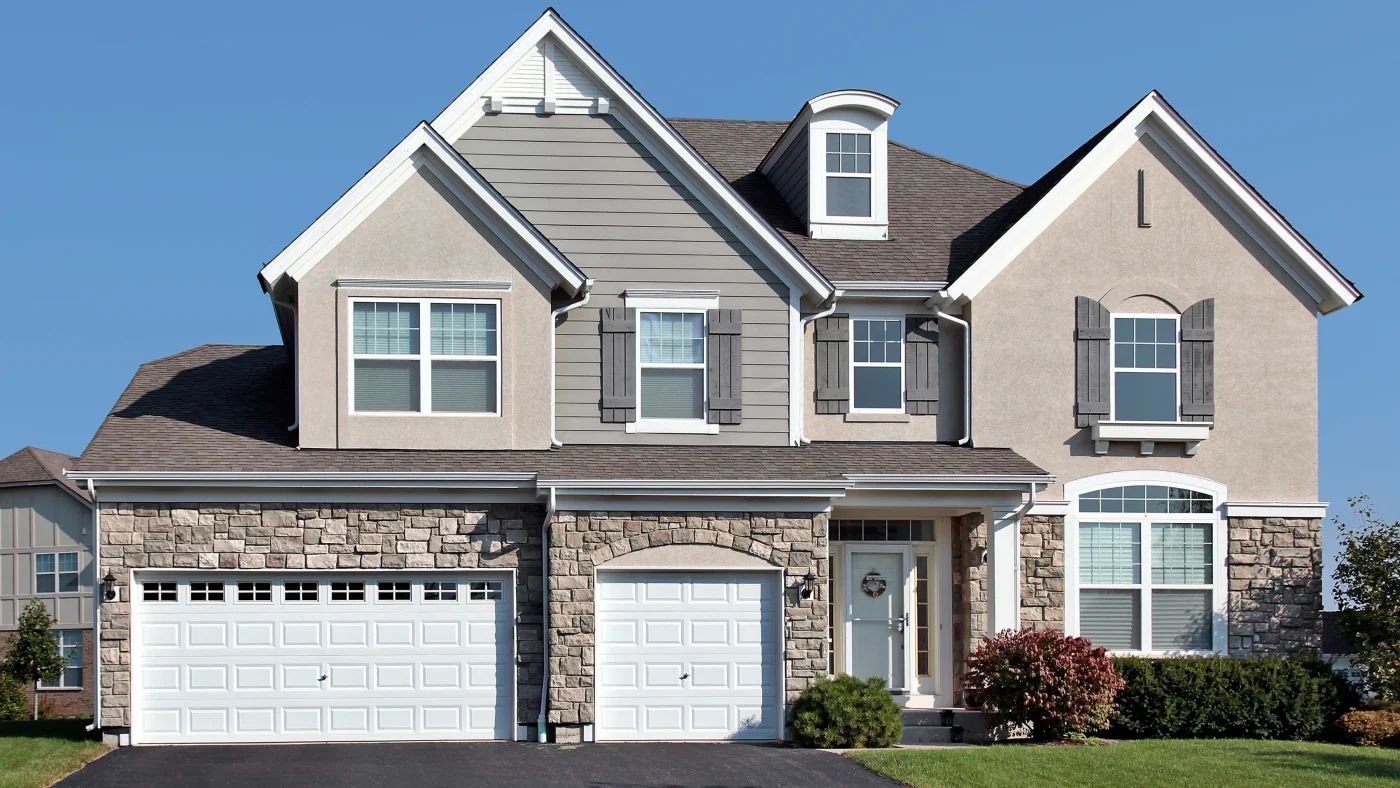 Exterior of a home with gray siding, stone accents, and gray stucco