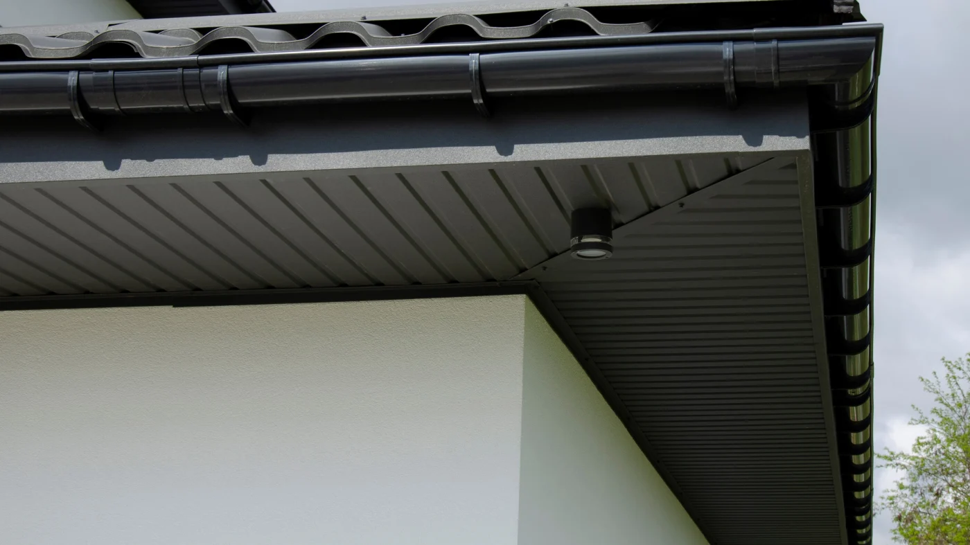 An angled upward view looking at the soffit and gutter of a home