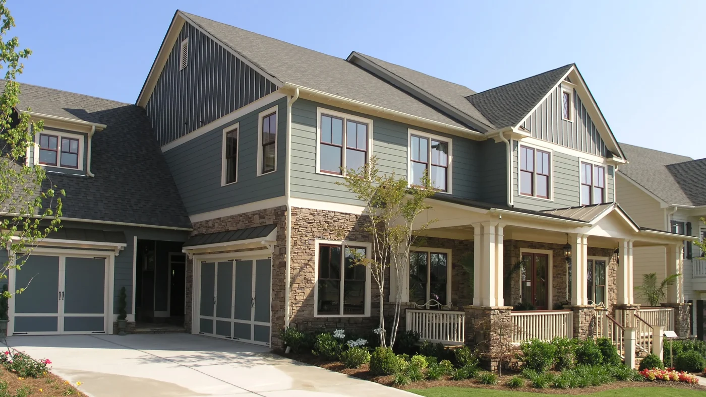 Exterior of a home with green siding, stone accents, and white trim