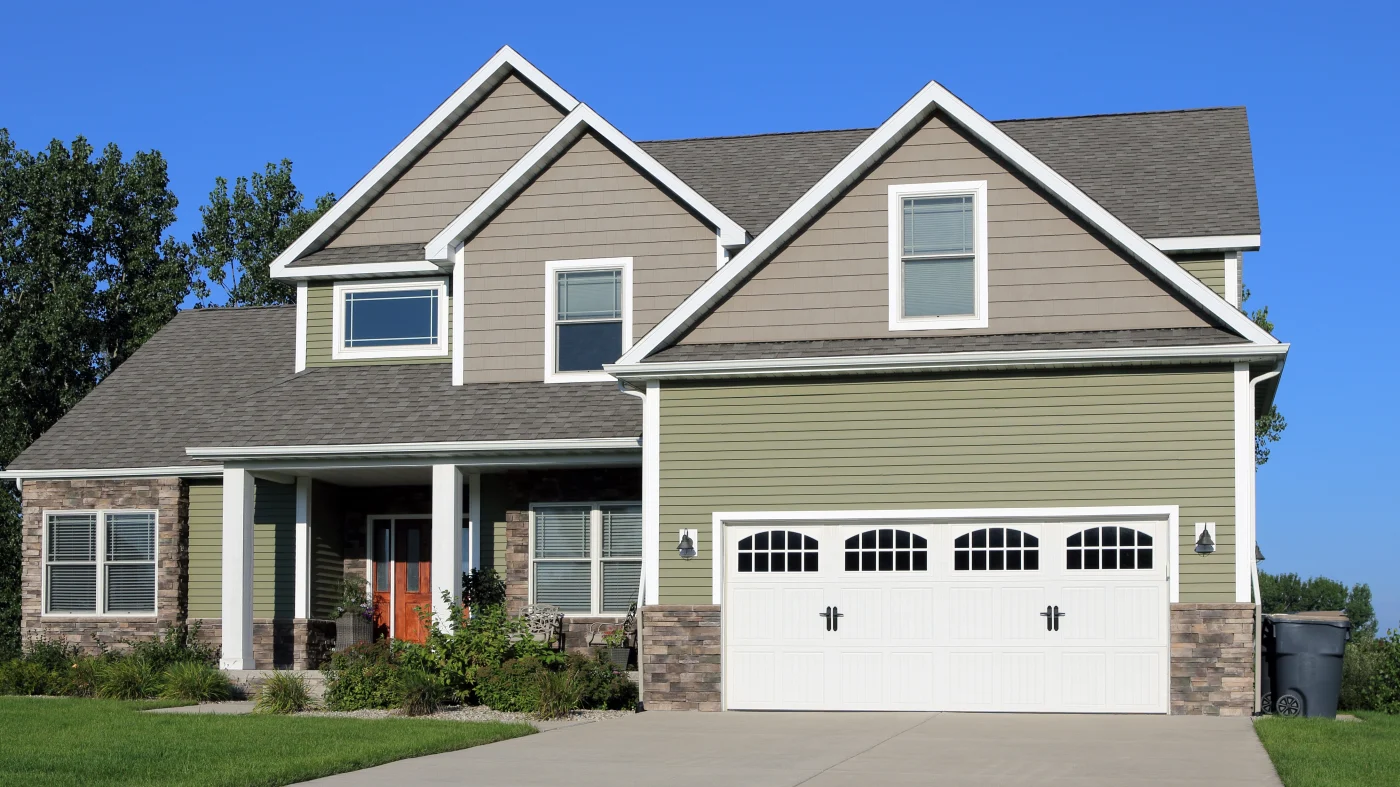 Exterior of a home with green and tan siding and white trim
