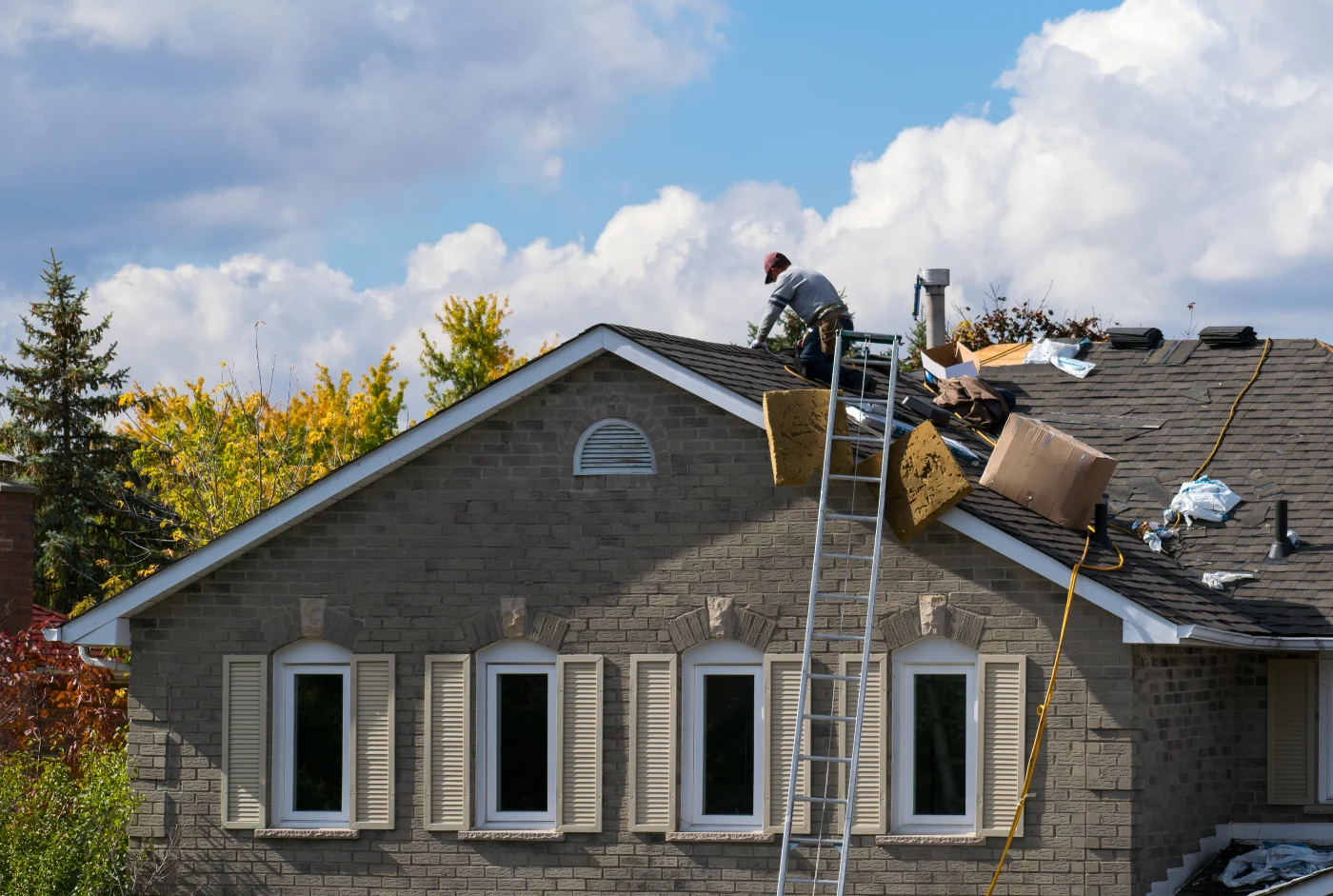Roof showing storm damage and in-progress restoration