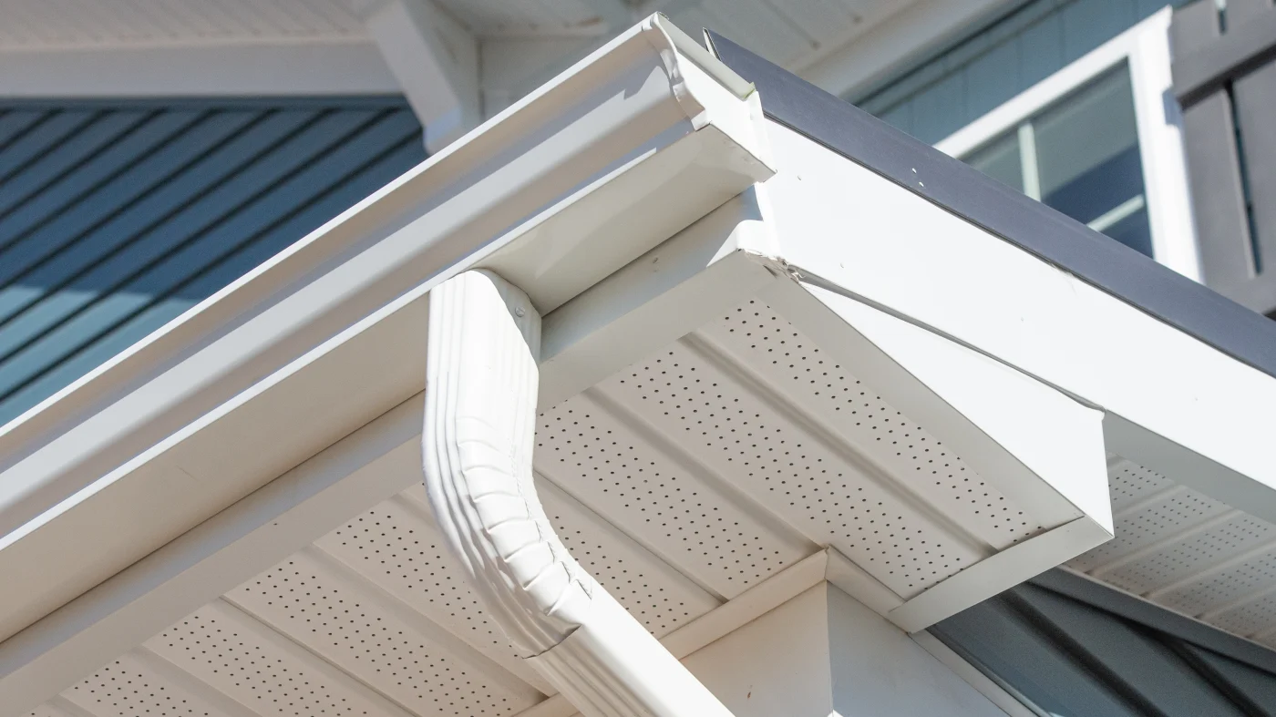 White seamless gutters above a white soffit on a home with blue siding
